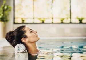 Healthy beautiful woman relaxing at spa swimming pool