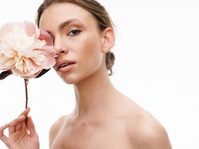 beautiful caucasian young shirtless woman holding peony flower