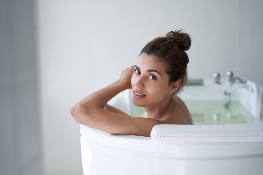 Smiling, beautiful woman relaxing during hydrotherapy in a spa salon, enjoying the benefits of a Nordic cycle treatment