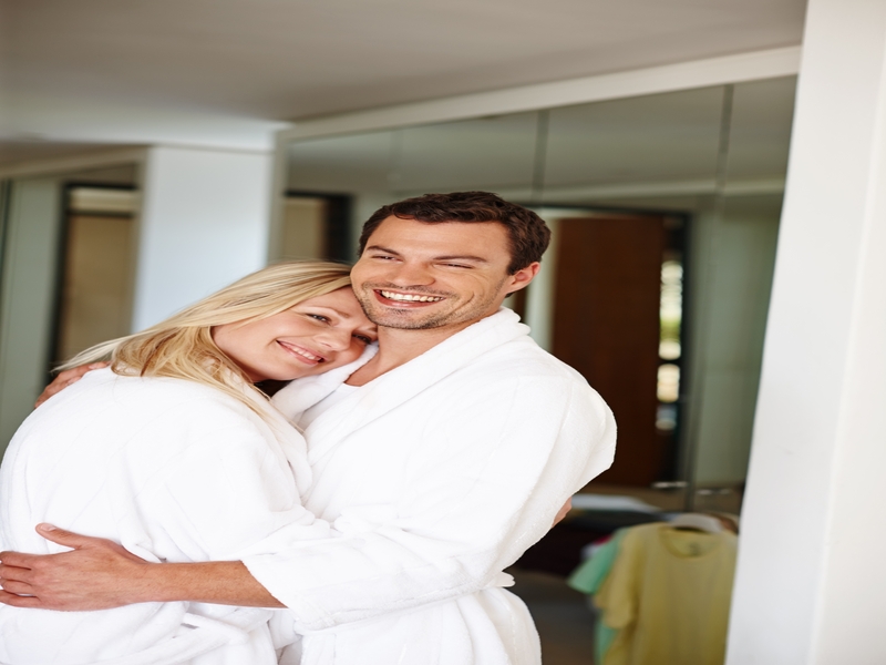 Happy couple embracing in a spa setting, smiling and enjoying relaxation, affection, and bonding during a wellness retreat or medspa stay