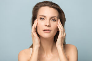 Skinwave facial treatment portrait of young woman with perfect skin touching her face, showcasing natural beauty and healthy skincare results